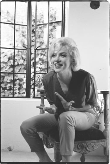 a black and white picture of Marilyn Monroe talking and gesticulating on a chair