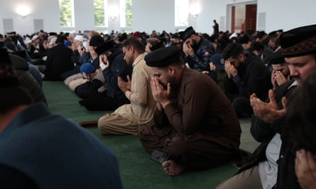 Men kneeling for Eid prayers at Baitul Futuh mosque