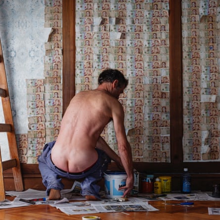 Werning a photographié son mari tapissant des murs avec des billets de 10 pesos – ce qui est moins cher que d'acheter du papier peint. Le pantalon de son mari est porté délibérément bas,