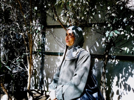 A woman stands amid dappled sunlight