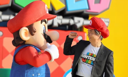 Shigeru Miyamoto elbow bumps with Mario during the opening ceremony of Super Nintendo World at the Universal Studio Japan in Osaka.