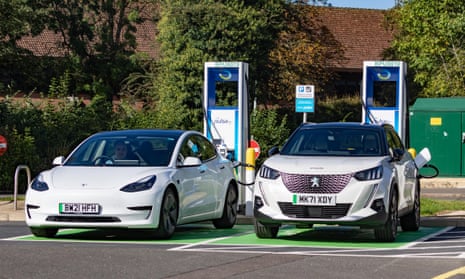 Two electric cars recharge at a service station