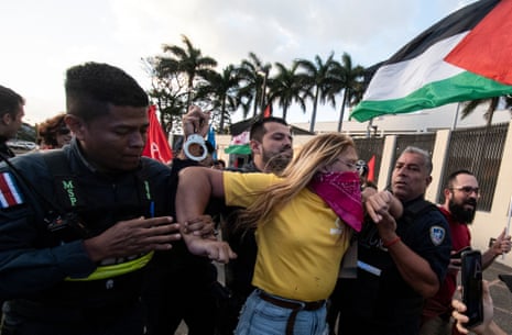 A woman is detained by police in San Jose, Costa Rica, during a demonstration in front of the US embassy, in support of the people of Gaza and against US support of Israel in the war