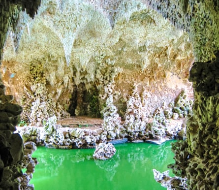 A grotto with green water and sculpture-like rock formations