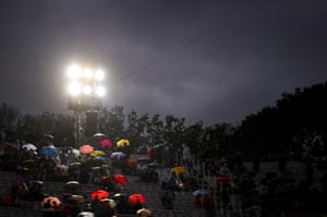 Tennis spectators sit in the rain