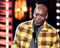 Dave Chappelle on stage in 2021 with microphone.
