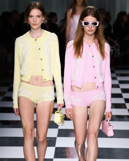 Models wearing pastel hot pants and carrying tiny handbags walk the catwalk.