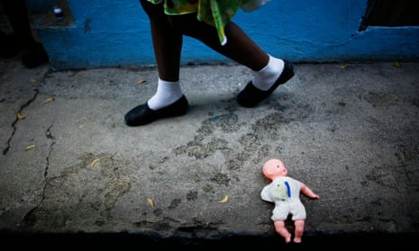 Child walks past doll on ground.