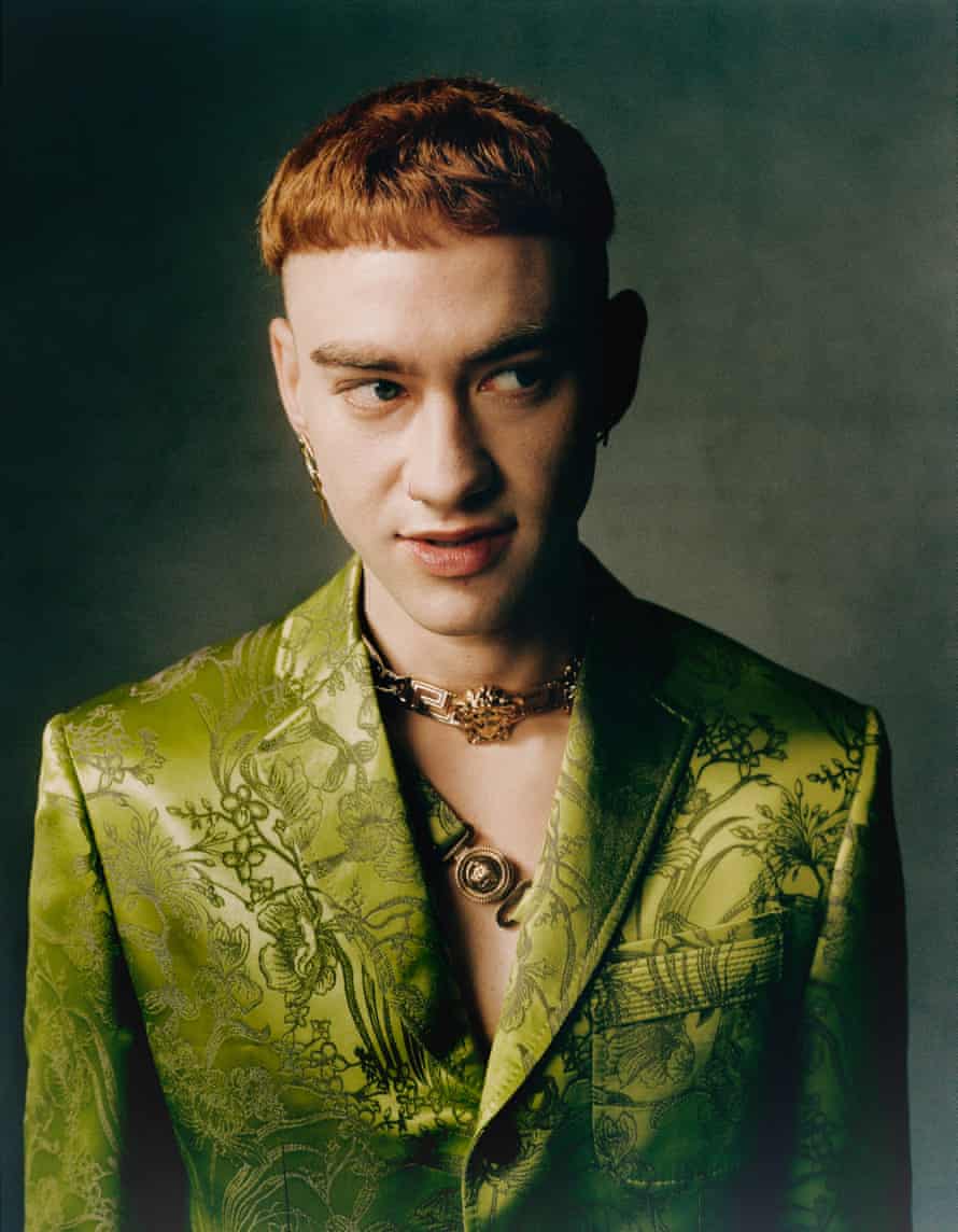 Olly wears suit and necklace: Versace. Earrings: Freya Douglas Ferguson and Hatton Labs. Hair: Reve Ryu. Makeup: Joe Brooks. Photographer’s assistants: Ben Kyle and Connor Egan. Styling assistants: Anna Viazikova and Salome Rosé. Floral styling assistant: Jameka Herman.