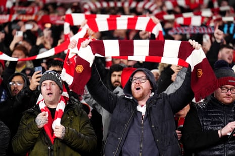 Arsenal fans hold up their scarves as they sing and show their support ahead of the Carabao Cup semi-final second leg match against Chelsea.