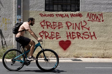 A man rides a bike past graffiti in support of hostages kidnapped during the 7 October attack on Israel by Hamas, in Tel Aviv on Thursday.