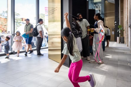 Families in the HUMANS exhibit, with a girl in pink pants running with a kite
