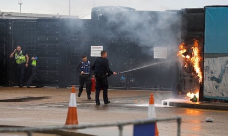 Members of the military and UK Border Force extinguish fires after the attack on a Dover immigration centre.