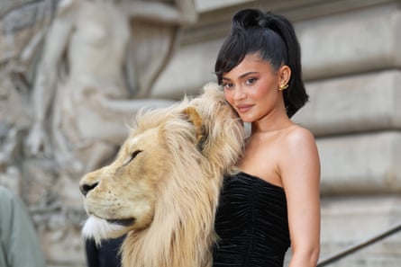 Jenner in black, strapless dress with large fake lion’s head