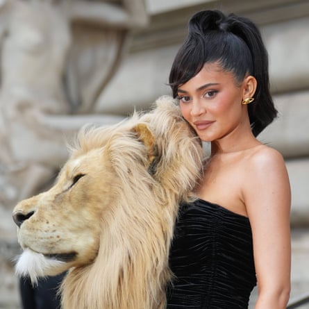 Kylie Jenner in strapless black dress and lion's head adornment.