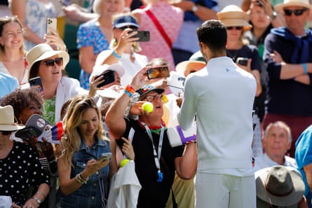 Novak Djokovic signs autographs after his second-round win against Dan Evans
