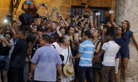 Tourists and local residents take pictures of President Barack Obama as he tours Old Havana.
