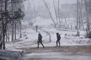 Pro-government forces walk as snow falls in Aleppo
