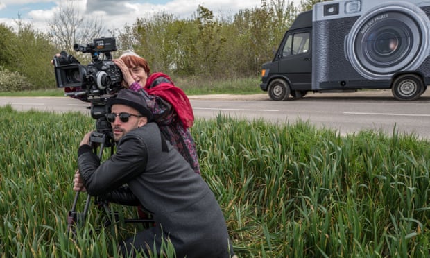 Still from Faces Places, showing the two directors and stars with a camera in a field.