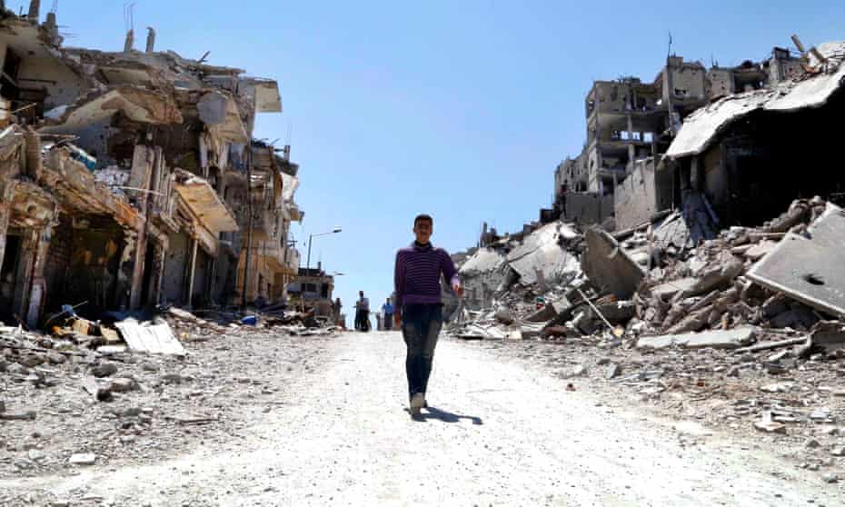 Residents arrive on foot to inspect their homes in the Wadi Al-Sayeh district at the al-Khalidiyeh area in Homs.