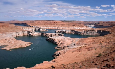 A dark blue river flowing between red and brown canyons
