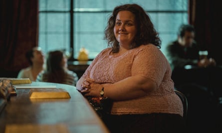 Woman sitting at a bar smiling in a scene from the Netflix hit drama series Baby Reindeer