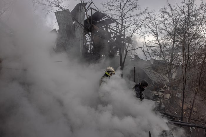 Firefighters stand in smoke after Russian artillery shelling on the outskirts of Kharkiv, northeast Ukraine.