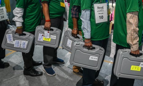 Volunteers carry Electronic Voting Machines at an election vote counting station in Mumbai on 4 June 2024.