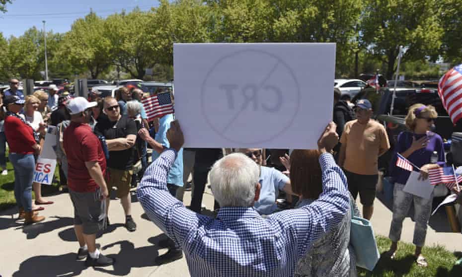 Een man houdt een bord omhoog tegen de kritische rassentheorie tijdens een protest buiten een schoolbestuursvergadering in Reno, Nevada, in mei.