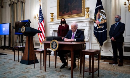 Joe Biden, flanked by Kamala Harris and Anthony Fauci, signs a series of executive orders aimed at tackling the coronavirus crisis.