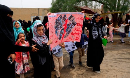 Yemeni children raise signs and chant slogans during a demonstration against the airstrike on the school bus.
