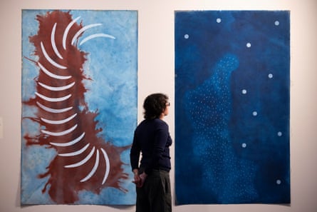 Two vertical paintings, one features a blue backdrop with stars, the other depicts a series of white, rib-like shapes lying over a splash of red on a background of pale blue