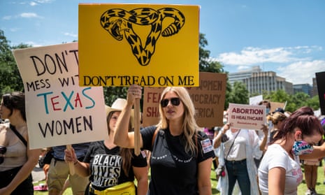 Protesters hold up signs at a protest outside the Texas state capitol on 29 May in Austin, Texas.