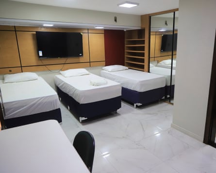 A modern hotel room with three single beds