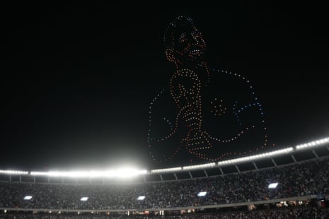 A drone display showing Messi holding the World Cup trophy hovering over a full stadium.