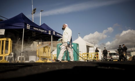 A worker sanitises the area used by migrants at the Arguineguín port.