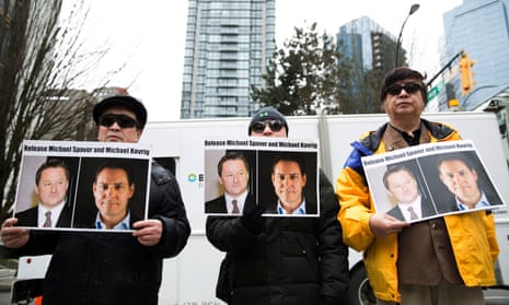 Protesters hold photos of Canadians Michael Spavor and Michael Kovrig, who are being detained by China, outside British Columbia Supreme Court, in Vancouver. 