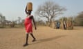 a woman carries water back to her village