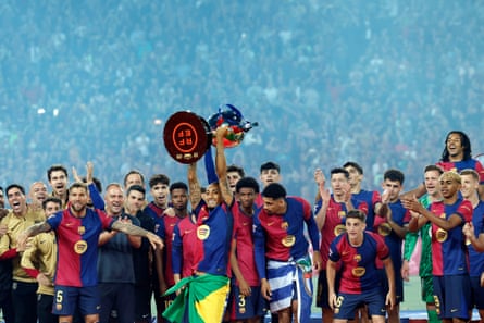 The Barcelona players pose with the league trophy despite their defeat.