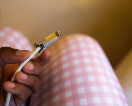 A woman holding badly frayed charging cable