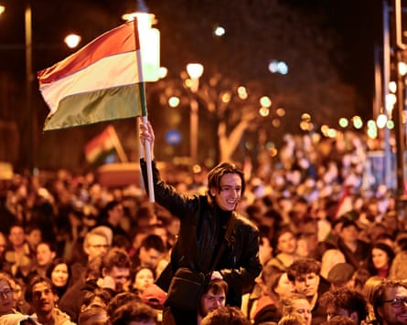 A man waves a Hungarian flag as he celebrates in the streets