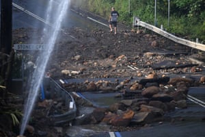 Man navigating through debris and a burst water main