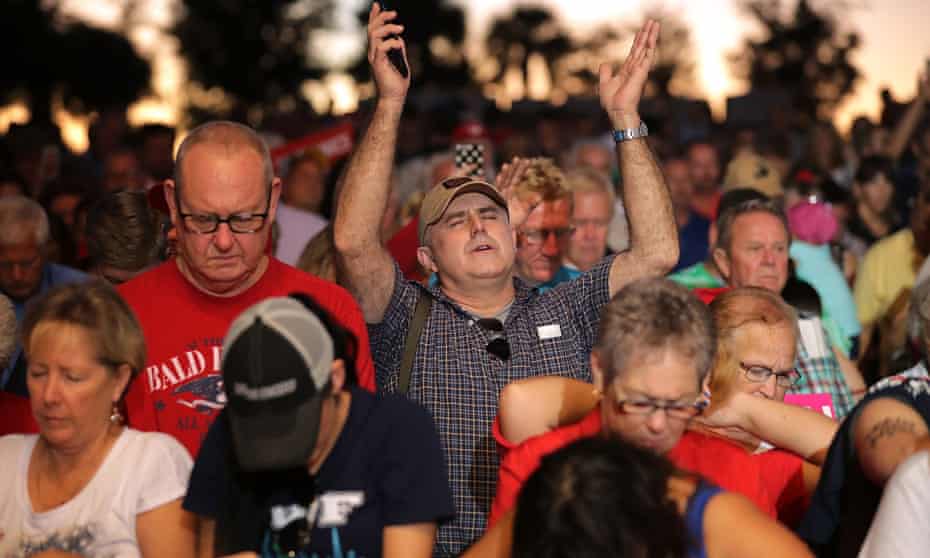 Supporters pray during a campaign rally fro Donal Trump in Pensacola, Florida.