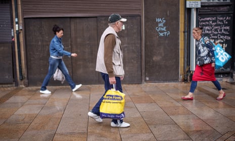 Shoppers walk past graffiti in Stoke-on-Trent