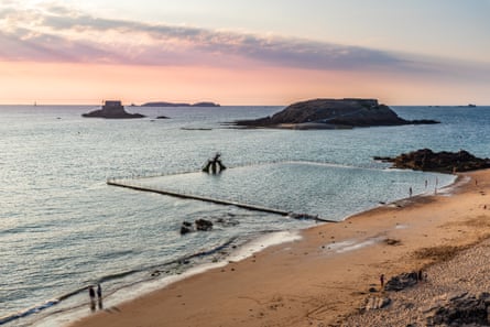 A beach with tidal pool at sunset