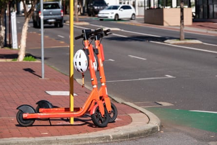 Orange e-scooters on street corner