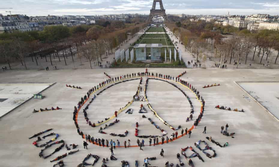 Environmental activists form a human chain to make the peace sign and spell out ‘100% renewable’ at last year’s UN climate change talks in Paris. 