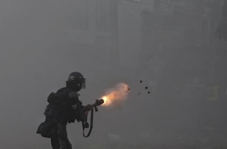 A police officer fires tear gas