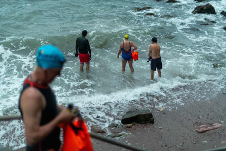 Members of the Torquay Shoal Outdoor Swimming group, taking to the water at Antsey’s Cove, Torquay, Devon., on the longest day of the year.