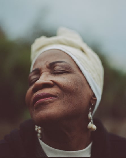 a portrait of a woman raising her face and smiling slightly